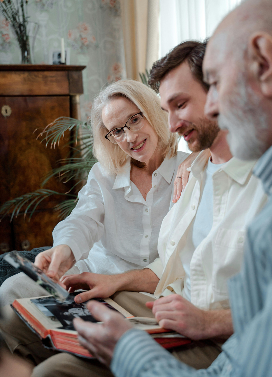 elderly-couple-looking-at-photos-with-son